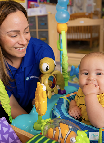 Teacher and baby playing with colorful toys